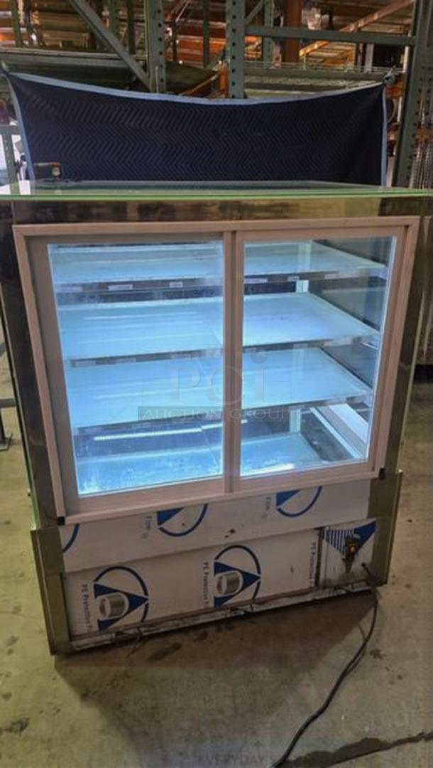 Commercial bakery display case, enclosed with glass doors, in remarkable condition. Fully tested and working, with shelves lit.