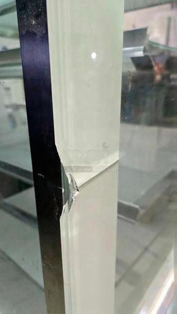 Cracked glass on commercial bakery display case. Black metal frame with visible wear. Fully tested, working condition.