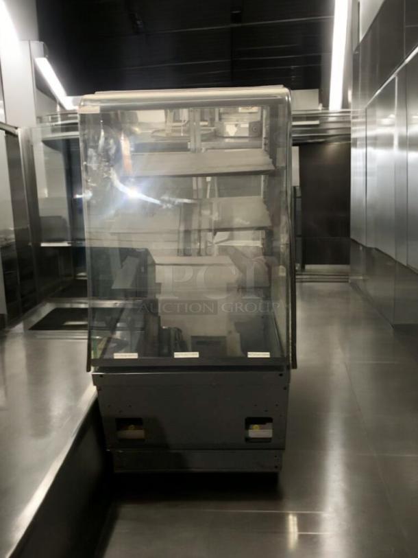 Superior condition refrigerated bakery/deli display case with curved glass, multi-shelf interior. Fully tested, operational.