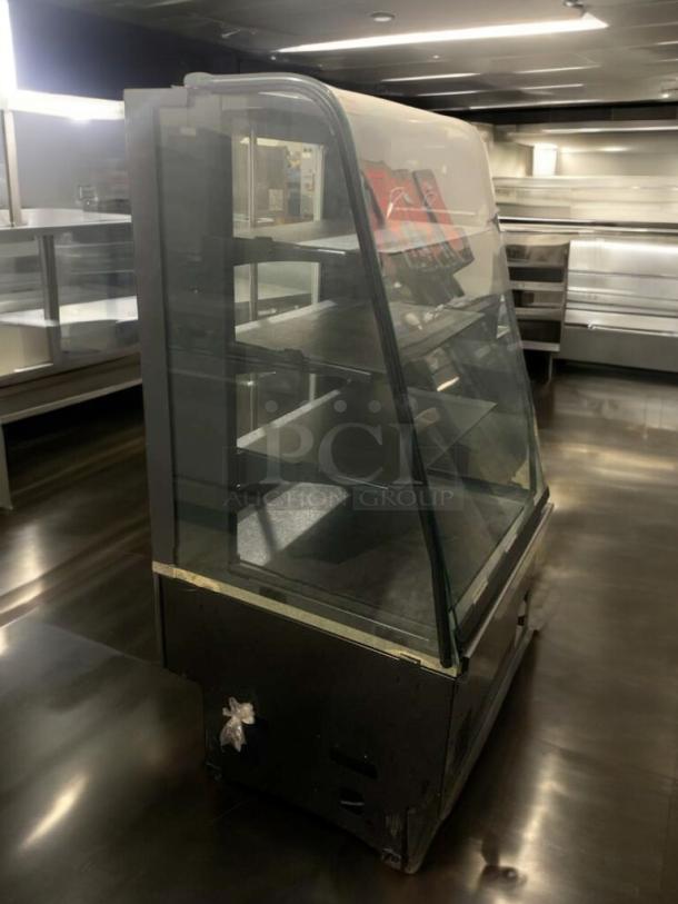 Commercial refrigerated display case with curved glass and multiple shelves, in superior condition, fully tested and operational.