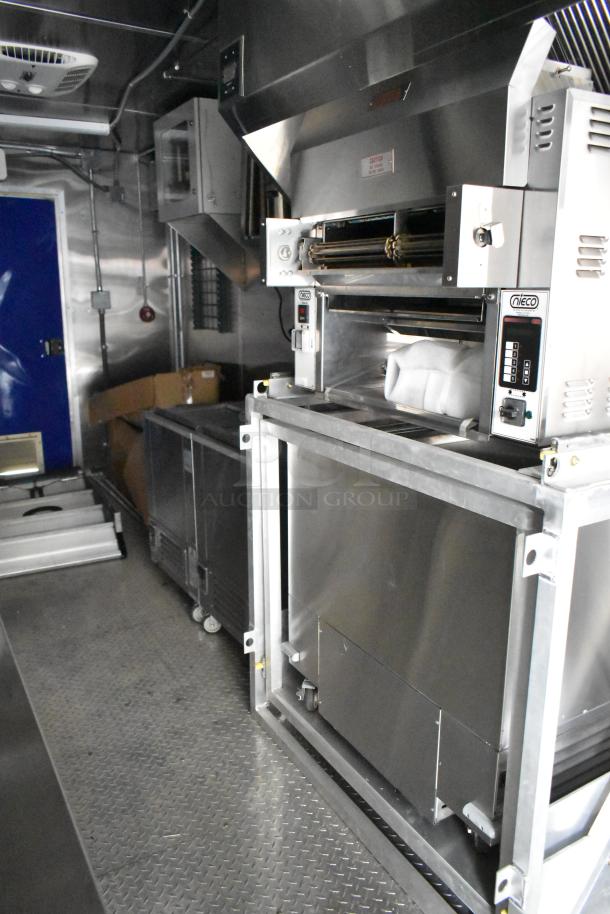 2021 Cruising Kitchens 24' fast food trailer interior, featuring Nieco broiler, CaptiveAire grease hood, True coolers.