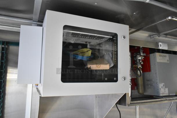 Interior of a 2021 Cruising Kitchens 24' fast food trailer, featuring a wall-mounted control panel in a pristine condition.