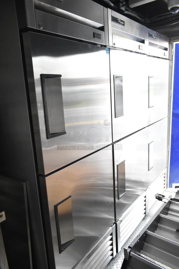2021 Cruising Kitchens 24' fast food trailer interior showing stainless steel True freezers and cooler, pristine condition.