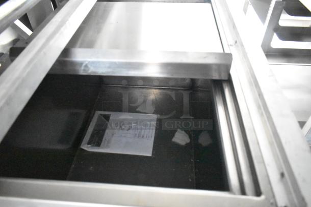 Interior view of a new 24' Cruising Kitchens Burger King trailer, showing stainless steel shelving and enclosed documents.