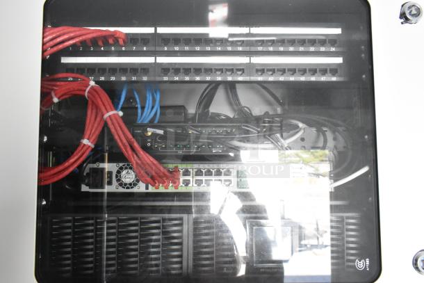 Networking panel inside cold food & beverage trailer with neatly organized red and blue cables, switchboard, and protective case.