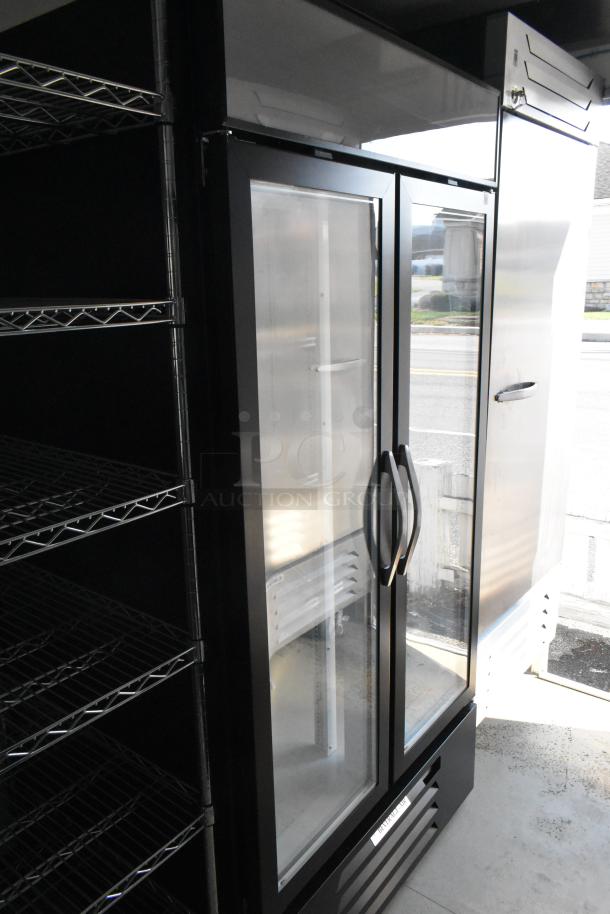 Alt text: Nationwide 24' trailer interior showing wire shelving and Beverage Air glass-door cooler and freezer.