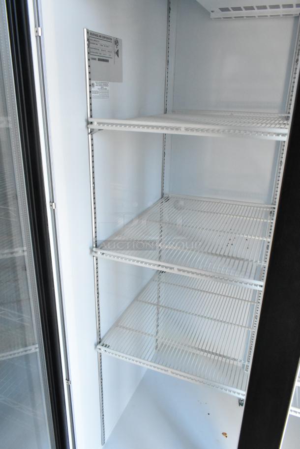 Interior of a Beverage Air reach-in cooler, featuring adjustable wire shelves, clean white finish, and a visible manufacturer label.