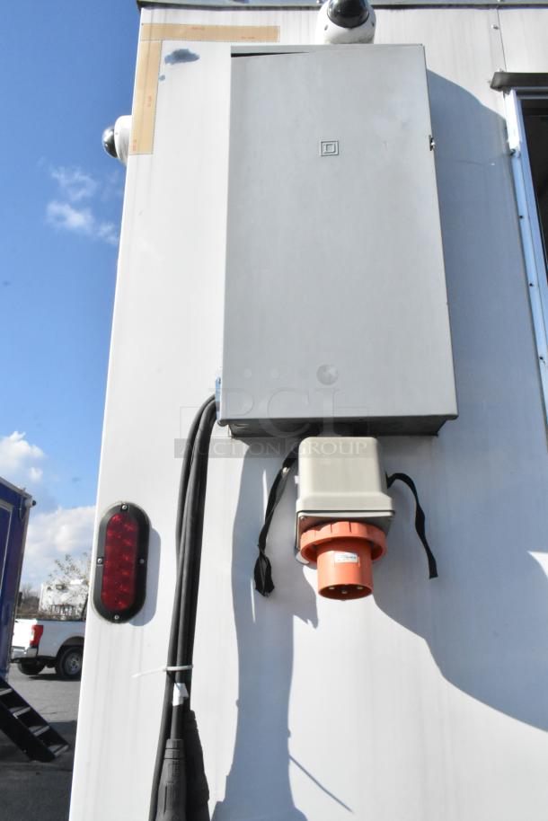 Exterior view of a Nationwide 24' cold food and beverage trailer, showcasing electrical hookup and security cameras.