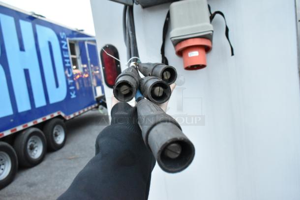 Alt text: Cables and power hookup on a Nationwide 24' unbranded cold food and beverage trailer. Visible trailer and electrical outlet.