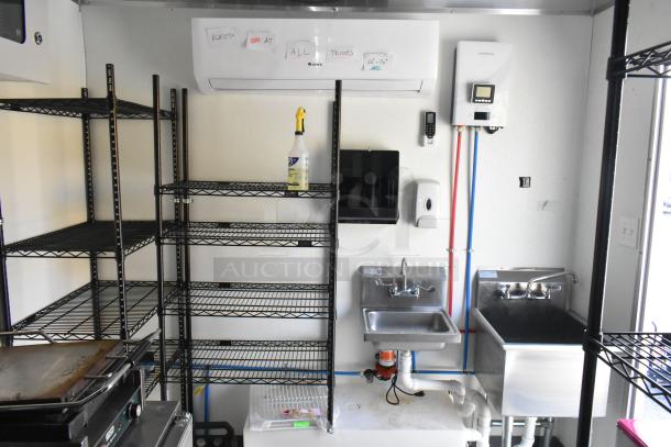 Inside view of a fully outfitted 24' cold food and beverage retail trailer, with shelving, sinks, and cooling units.