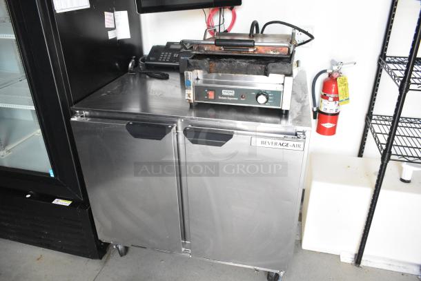Beverage Air reach-in cooler with Waring panini press on stainless steel countertop in a retail trailer.