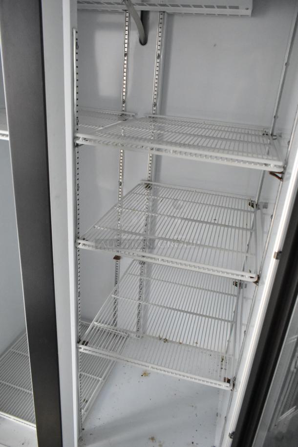 Inside view of a cold food retail trailer's empty Beverage Air reach-in cooler with multiple wire shelves.