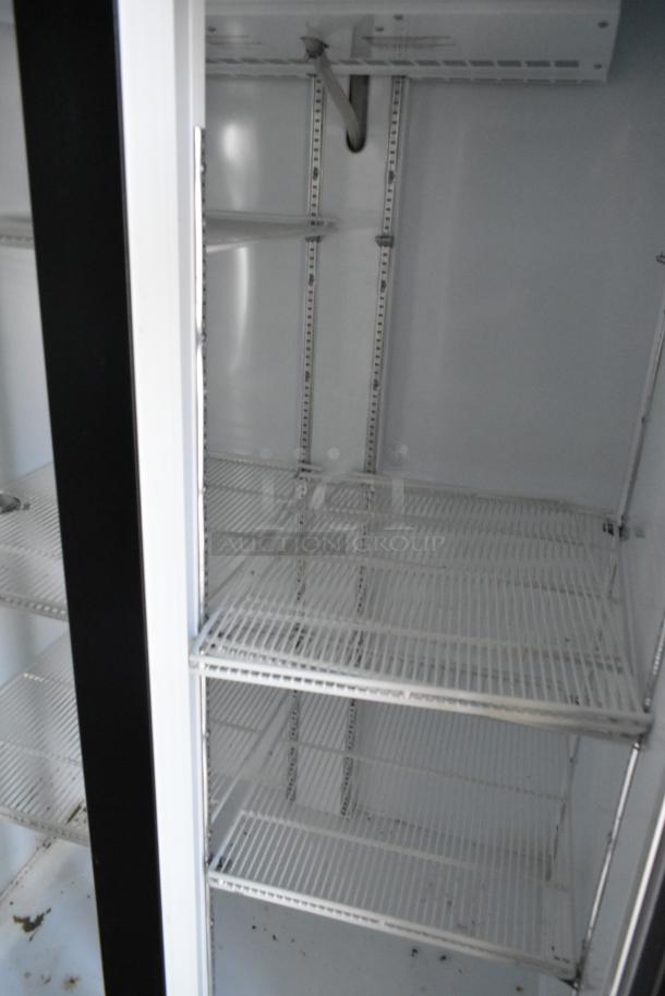 Interior view of a fully outfitted cold food retail trailer showing empty wire shelving and part of a cooling system.