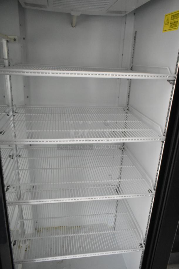 Empty commercial-grade fridge with wire shelves, interior view. Ideal for cold storage in a food retail trailer.