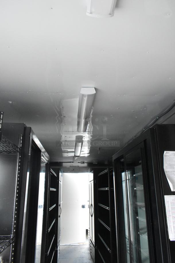 Inside view of a Nationwide 24' retail trailer. Features shelving units, coolers, and commercial-grade equipment. Brand new condition.