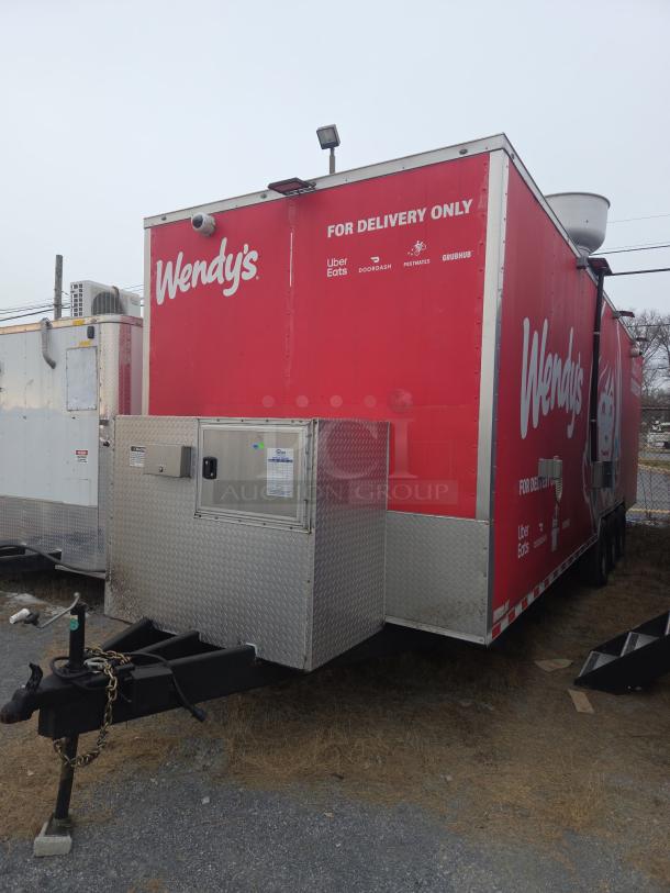Red Wendy's food delivery trailer with logos for Uber Eats, DoorDash, Postmates, Grubhub. Features diamond plate metal siding.