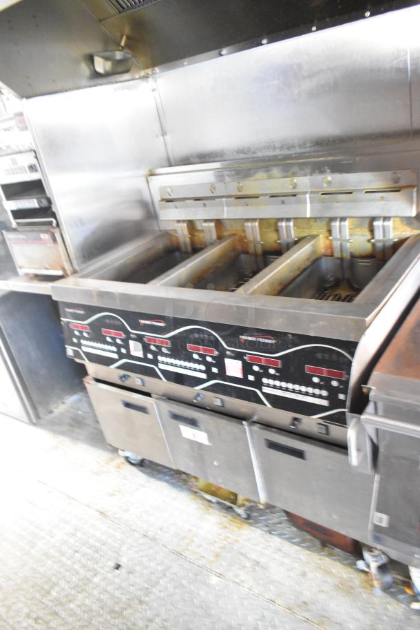 Commercial deep fryer with multiple fry pots, stainless steel construction, digital controls, and casters. Used condition.
