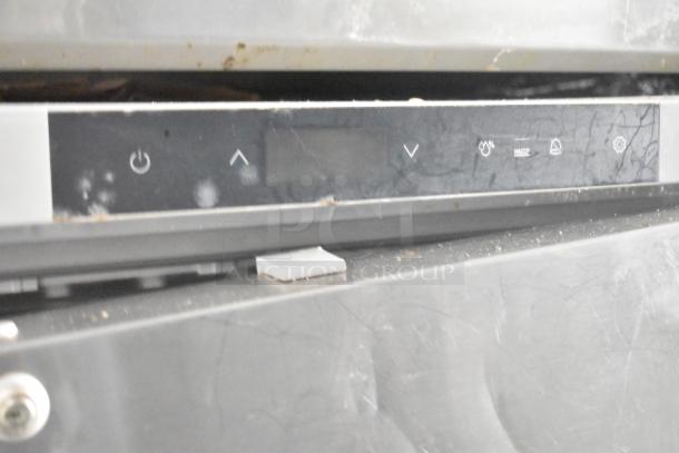 Industrial control panel with power and setting icons, slightly worn condition, black surface with visible marks and smudges.