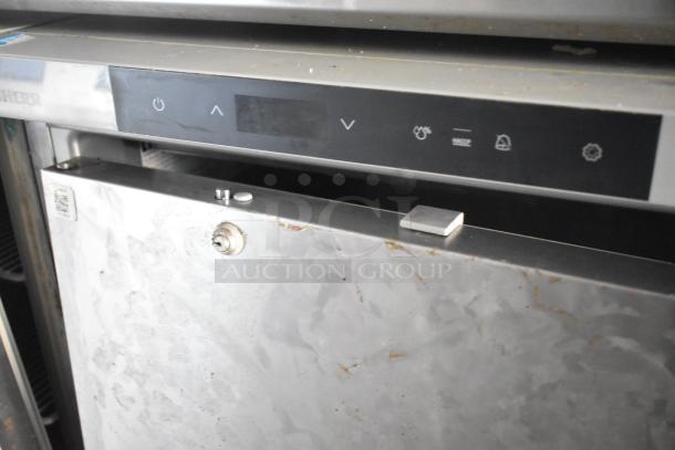 Stainless steel industrial appliance with digital controls, slight wear. Features lock mechanism, manufacturer's logo partially visible.
