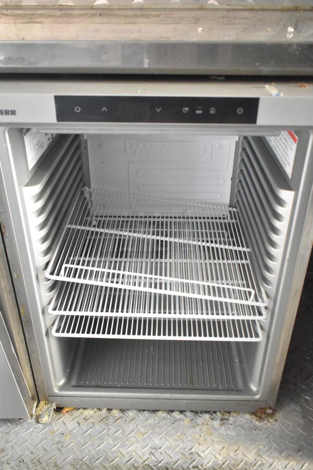 Commercial refrigerator with multiple wire shelves, digital controls, and visible interior markings. Used condition.