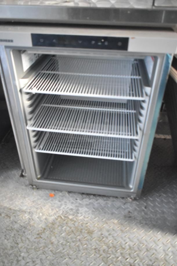 Commercial refrigerator with three wire shelves, stainless steel finish, digital control panel, clean interior, and sturdy construction.