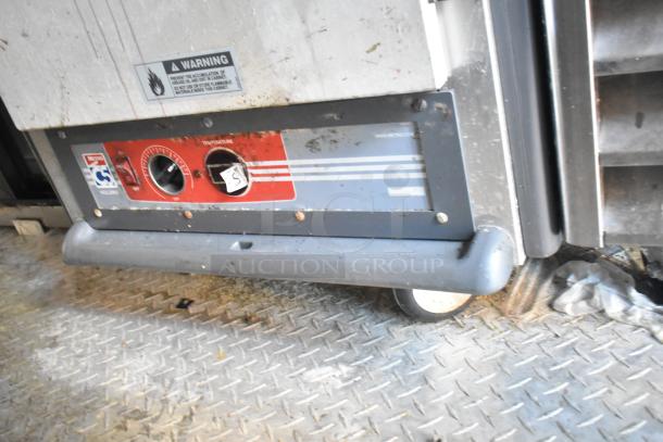 Commercial oven base, featuring temperature controls and warning label. Appears used with visible wear and dirt.