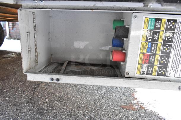 Electrical panel box with colored wire connectors and labeled instruction diagram on fast food trailer.