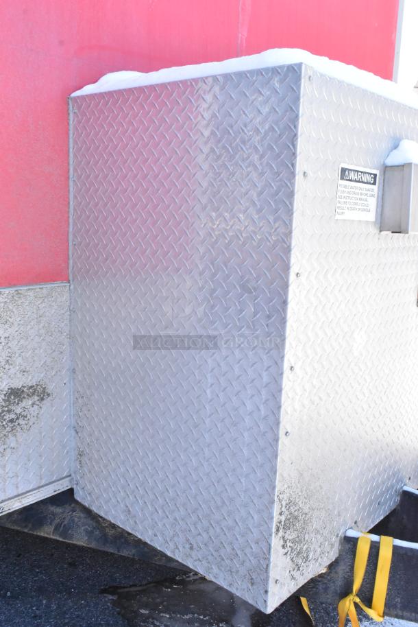 Aluminum-clad exterior of a 28' Wendy's mobile kitchen trailer, featuring a warning label.