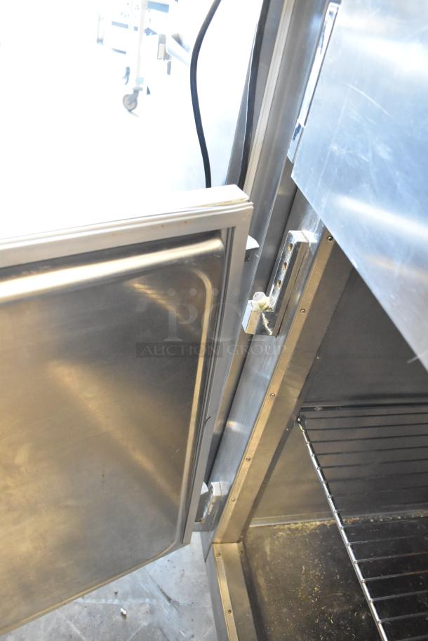 Traulsen RHT132WREHHS stainless steel half-door reach-in cooler, 115 volts, 1 phase, interior shelving visible, good condition.