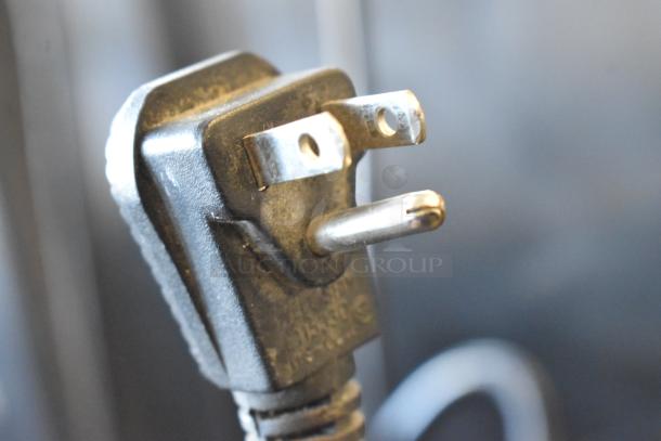 Electrical plug of the Traulsen RHT132WREHHS Reach In Cooler, 115V, 1 Phase, with visible prongs and cord in focus.