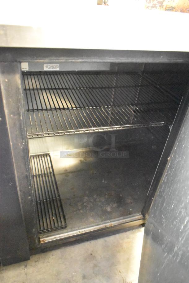 2017 True TBB-4-HC Commercial 3-Door Back Bar Cooler, metal, 115 volts, 1 phase, open door showing interior shelves.