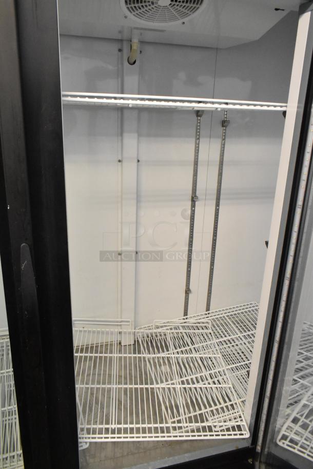 Central 69K-056 metal commercial 3 door reach-in cooler with poly-coated racks, 115 volts, 1 phase, shown open, interior view.