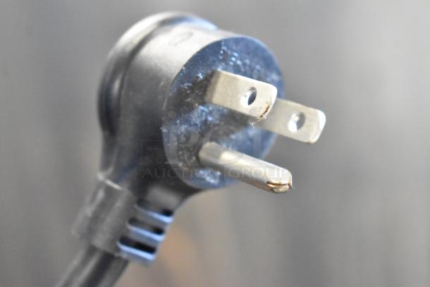 Close-up of a black three-prong plug from the 2018 True TBB-1-HC commercial cooler, showing slight wear. 115 Volts, 1 Phase.