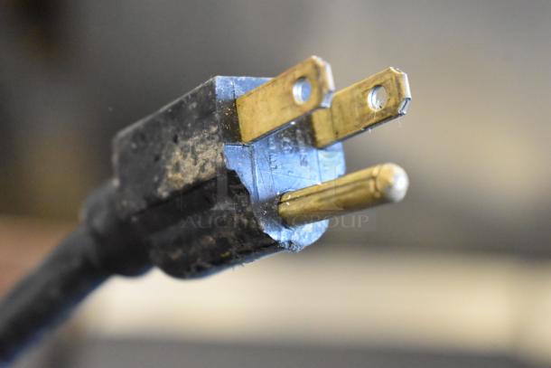 Close-up of a three-prong electrical plug for a Crathco 3311 frozen beverage machine, 115 volts, 1 phase.