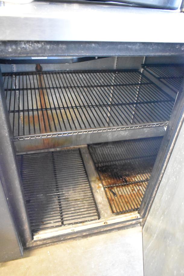 2017 True TBB-4-HC commercial back bar cooler, 3 doors, metal shelves, visible wear. Model TBB-4, 115V, 1 phase.