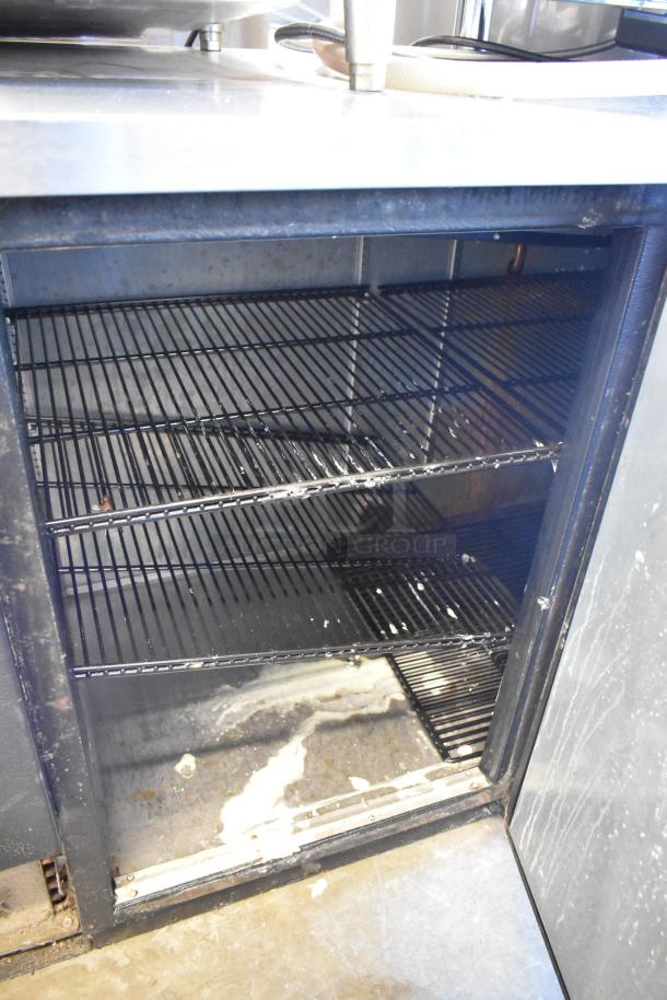 2017 True TBB-4-HC metal commercial 3 door back bar cooler, 115V, 1 phase, showing interior shelves, in used condition.
