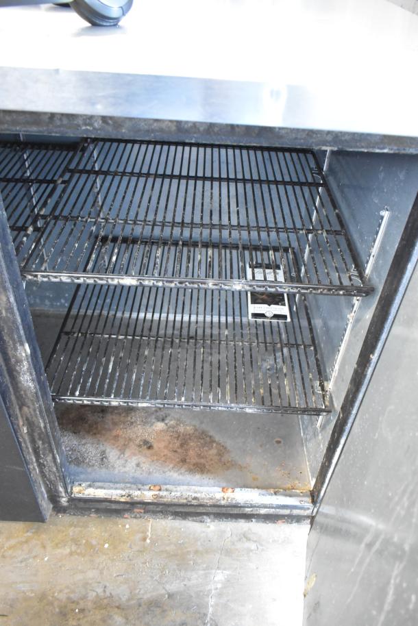 2017 True TBB-4 three-door back bar cooler, metal construction, visible wear, 115V, 1-phase, interior shelves shown.