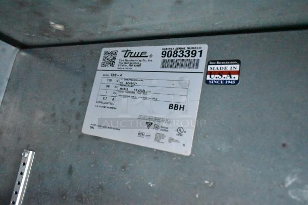 2017 True TBB-4 3 Door Back Bar Cooler, metal, 115 volts, 1 phase. Serial number 9083391, made in USA, label detail.