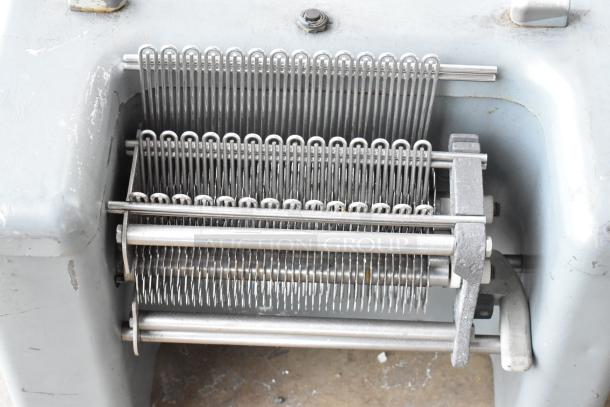 Metal commercial countertop electric meat tenderizer, 115 volts, 1 phase. Features sharp blades, sturdy construction.