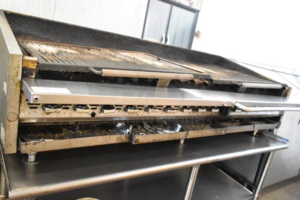 Stainless steel commercial countertop gas charbroiler grill on equipment stand, worn condition, visible controls and drip trays.