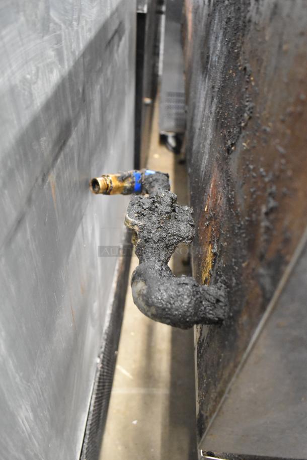 Stainless steel commercial countertop charbroiler grill, gas-powered, equipment stand, visible wear and grease buildup.