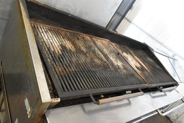 Stainless steel commercial countertop gas-powered charbroiler grill on equipment stand, showing signs of heavy use.