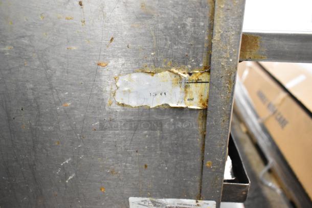 Stainless steel commercial countertop gas charbroiler grill with equipment stand, visible wear and tear, part of auction.