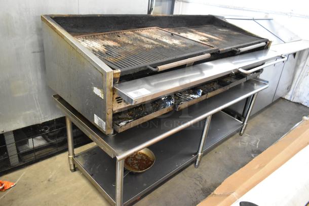 Stainless steel countertop gas charbroiler grill on metal stand, used condition, with visible grease stains and wear.