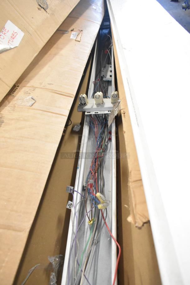 14 brand new scratch and dent items, including light fixtures and fluorescent tube light frames. Visible wiring and packaging.