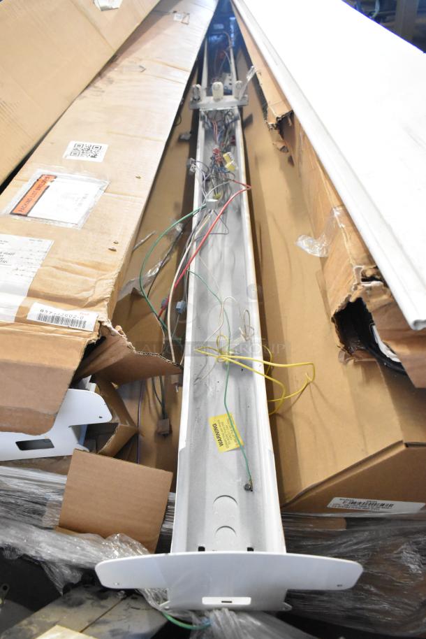 14 new scratch and dent items, including light fixtures and fluorescent tube light frames, packaged in boxes, wiring visible.