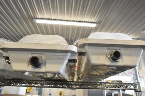 7 various light fixtures including Lithonia Lighting GTL 4 40L GZ10 LP840, white, ribbed design, moderate wear.