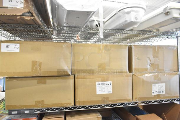 6 boxes of Dual Lite EVHC6IDP-WM LED lights, brand new scratch and dent condition, stacked on a metal shelf.