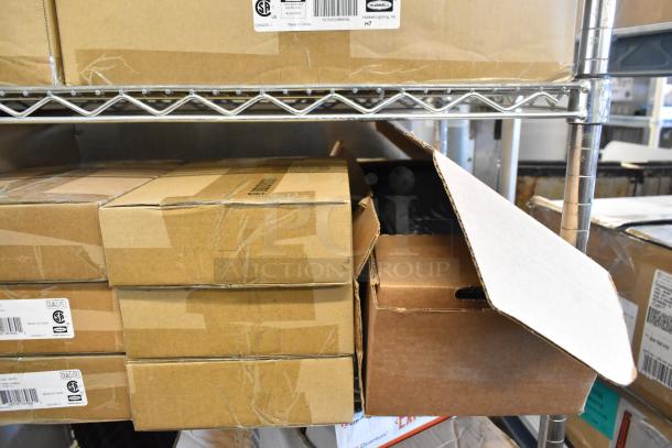 16 new scratch-and-dent boxes with Dual Lite LED emergency lights, exit signs, and remote heads. Labels show Hubbell Lighting branding.