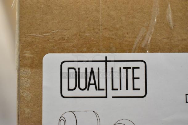 Cardboard box with Dual Lite label, indicating brand new scratch and dent items inside, including emergency lights and exit signs.